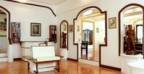 a living room with a chair and a mirror at Guindulman Bay Tourist Inn in Guindulman