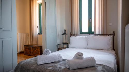 ein Hotelzimmer mit einem Bett, auf dem Handtücher liegen in der Unterkunft Porto Juno in Portianón