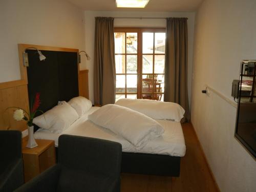 a hotel room with two beds and a window at Panorama Chalets am Pass Thurn in Mittersill