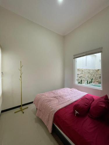a bedroom with a large bed and a window at infinite 88 villa in Batu