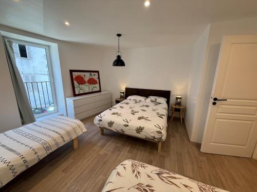 a bedroom with two beds and a window at Gîte Région des Lacs - SPA et Sauna Privatif in Orgelet