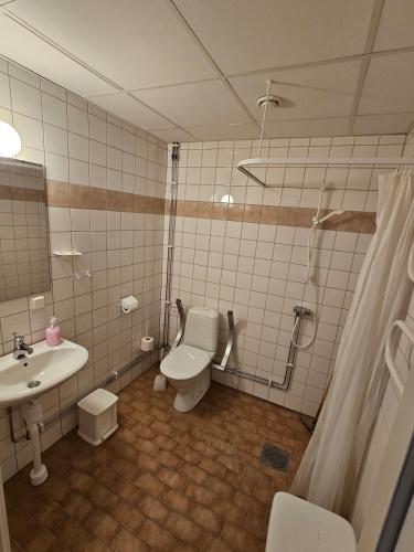 a bathroom with a toilet and a sink at EFS-gården in Åsljunga