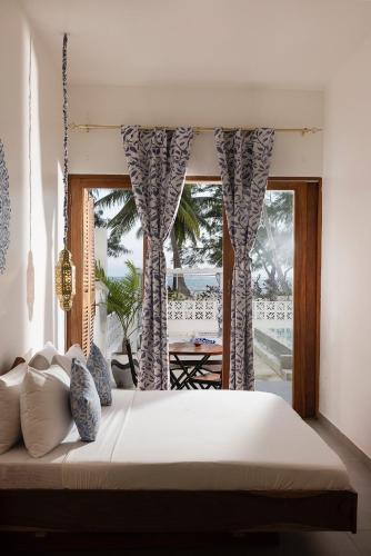 a bedroom with a large bed and a window at ZAN Orient Bwejuu Hotel in Makunduchi