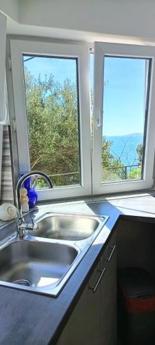 a kitchen with a sink and two windows at Drescher Apartments in Murter