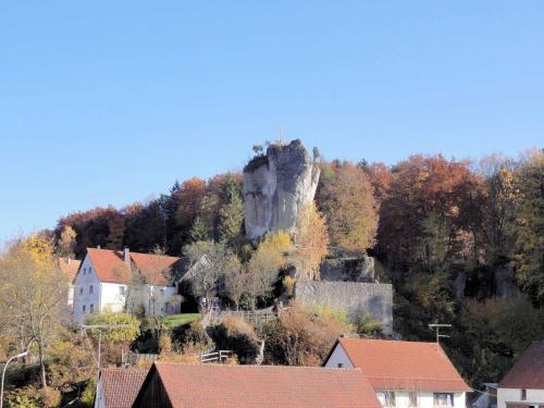 a castle on top of a mountain with houses at Haus Burgblick in Obertrubach