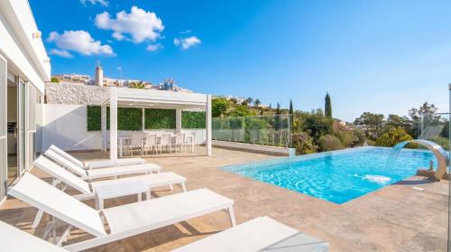 a villa with a swimming pool and a patio at Villa Gaia - Sunset Views, Indoor Heated Pool, Sauna and Games Room in Mellieħa