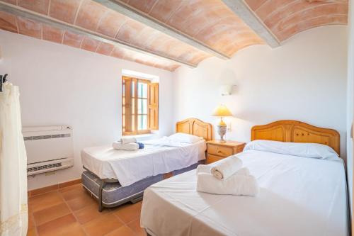 a bedroom with two beds with towels on them at Casa Can Pauma in Caʼs Concos