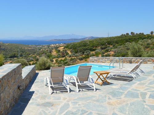 a group of chairs sitting next to a swimming pool at Villa Rokanes Glass Stone with Pool in Kouvéllai