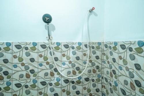 a shower with a blow dryer in a bathroom at RB Cottage Resort By ARBA in Palayangan