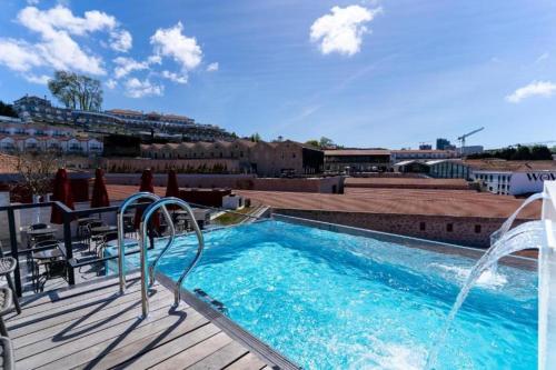 a swimming pool with a water fountain on a deck at Smartr Porto Reis de Gaia & Spa in Vila Nova de Gaia