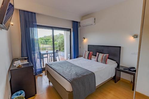 a hotel room with a bed and a balcony at Casa Do Vale Hotel by Umbral in Évora