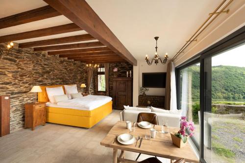 a bedroom with a bed and a table in a room at Mosel Panorama Studio auf Burg Coraidelstein in Klotten