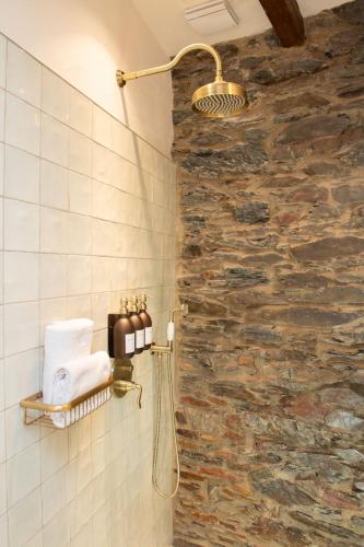 a bathroom with a shower with a stone wall at Mosel Panorama Studio auf Burg Coraidelstein in Klotten