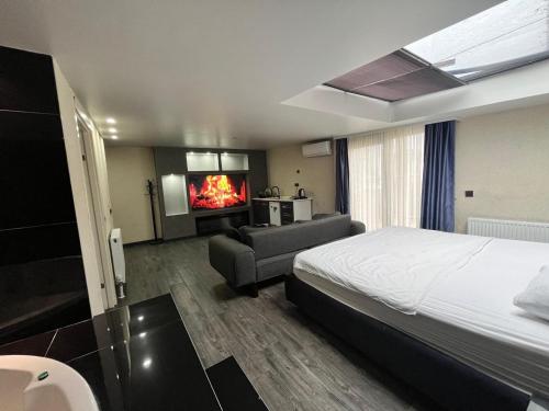 a hotel room with a bed and a couch and a fireplace at Kent Suites Hotels Ataşehir in Istanbul