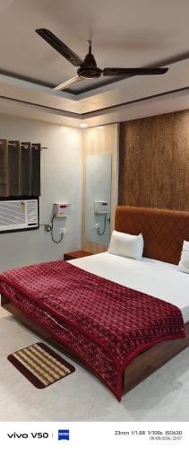 a bedroom with a large bed with a red blanket at Shree radhe palace in Datia
