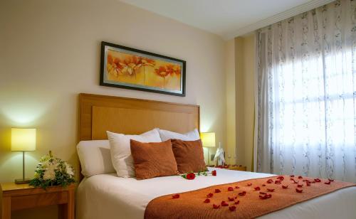 a bedroom with a bed with roses on it at Apartamentos Albatros Golf del Sur Tenerife in San Miguel de Abona