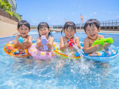 three children riding on inflatables in a swimming pool at Awakan in Sumoto
