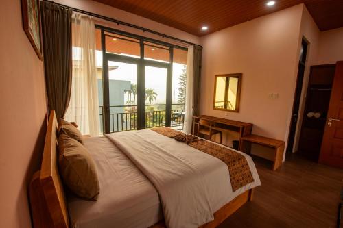a bedroom with a bed and a large window at Villa Favore in Puncak