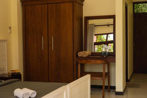 a bedroom with a bed and a desk and a window at URALSURF HOUSE in Weligama