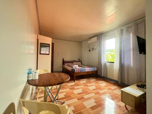 a small room with a table and a bed at ZM Residence in Dapa