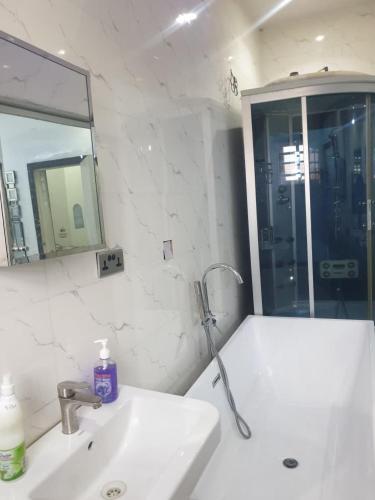 a white bathroom with a sink and a mirror at Sbk3apartments in Ologode