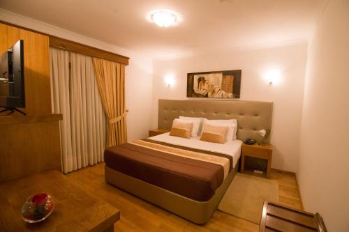 a hotel room with a bed and a television at Hotel Estalagem Turismo in Bragança