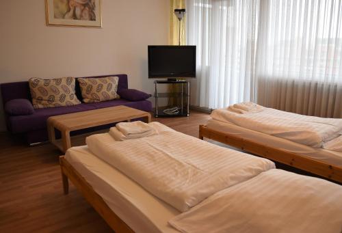 - un salon avec trois lits et un canapé dans l'établissement Work & stay Neuss, à Neuss
