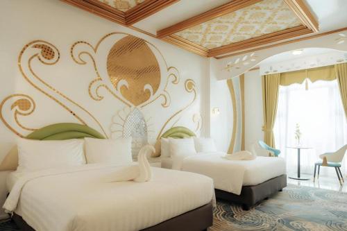 two beds in a hotel room with a wall mural at HOTEL VAN GOGH in Candon