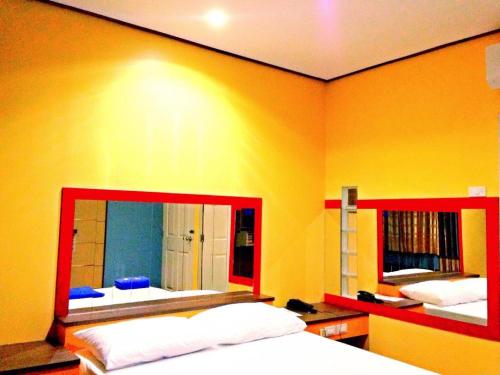 a bedroom with two beds and a large mirror at Zigzag Resort in Yasothon