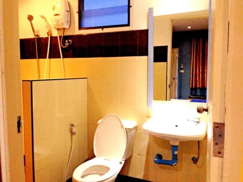 a bathroom with a toilet and a sink at Zigzag Resort in Yasothon