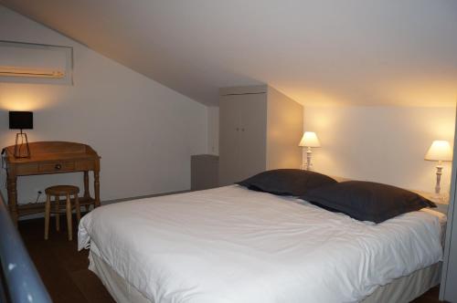 een slaapkamer met een groot wit bed en een tafel bij Domaine de la Girafe in Eyragues