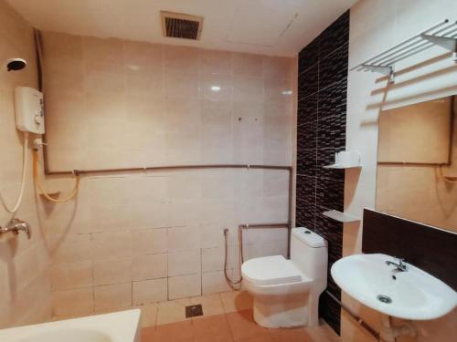 a bathroom with a white toilet and a sink at One World Lodging in Bentong