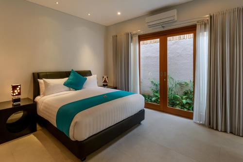 ein Schlafzimmer mit einem Bett und einem großen Fenster in der Unterkunft Villa Ley Seminyak by Best Deals Asia Hospitality in Seminyak