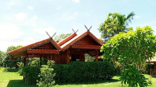 a small wooden house with a roof at Baanraimaetha Resort in Bān Phea