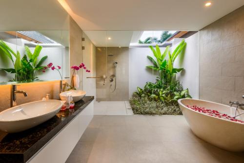 ein Badezimmer mit zwei Waschbecken und einer Badewanne in der Unterkunft Villa Ley Seminyak by Best Deals Asia Hospitality in Seminyak