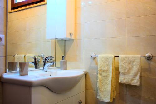 a bathroom with a sink and a mirror and towels at B&B Sedici Pini in Pomezia