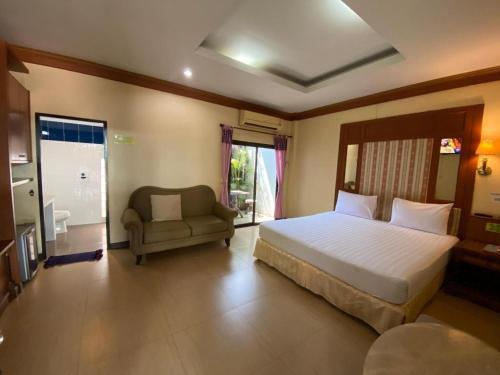 a bedroom with a large bed and a couch at My House in Surin