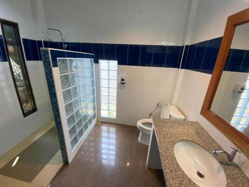 a bathroom with a sink and a toilet and a mirror at My House in Surin