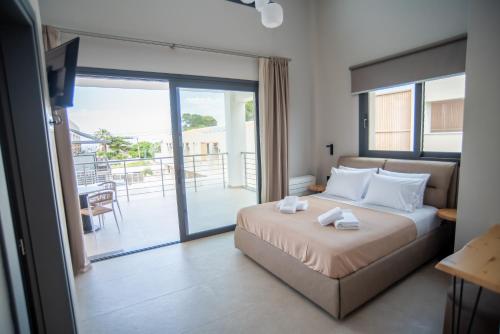 a bedroom with a bed and a balcony at Evaeri Suites in Mytikas