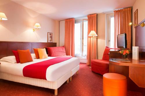 パリにあるオテル ロンドル サントノレの大きなベッドと赤い椅子が備わるホテルルームです。