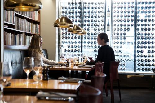 dos personas sentadas en una mesa en un restaurante en Mornington Hotel Stockholm, en Estocolmo