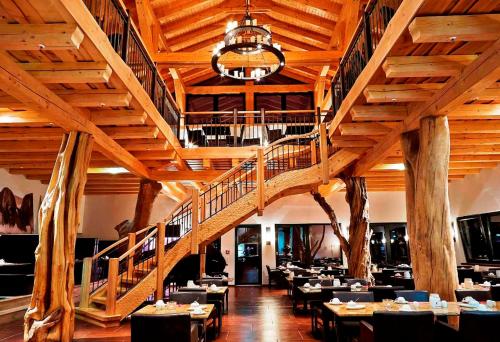 a dining room with tables and chairs and a staircase at Reit-und Sporthotel Nordmann in Stangerode