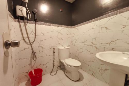 a bathroom with a shower and a toilet and a sink at Ecoland 88 Apartelle and Suite near SM Davao in Davao City