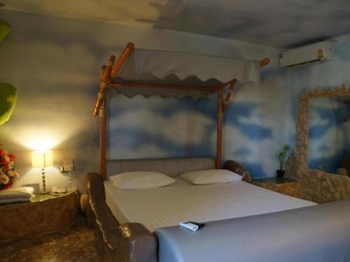 a bedroom with a bed with a wooden canopy at Fancy Resort in Ban Samran