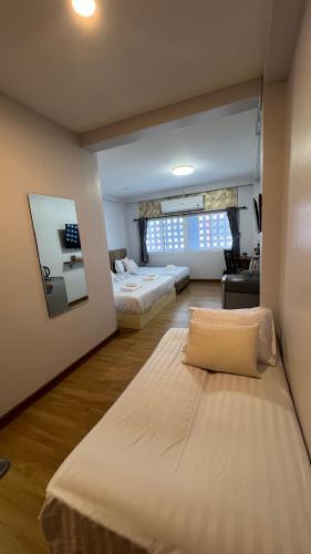 a bedroom with two beds and a large window at บ้านตลาด สัตหีบ in Sattahip