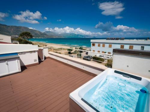 a hot tub on a balcony with a view of the ocean at CasaSol Deluxe villa sulla Spiaggia con Piscina e Jacuzzi By Sicily Home Solutions in Alcamo
