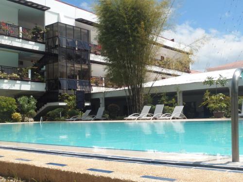 a swimming pool in front of a building at Jamont Hotel in Sipalay