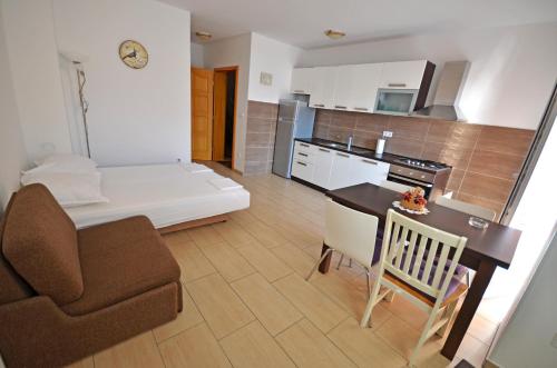 a living room and kitchen with a couch and a table at Apartments Jela in Metajna