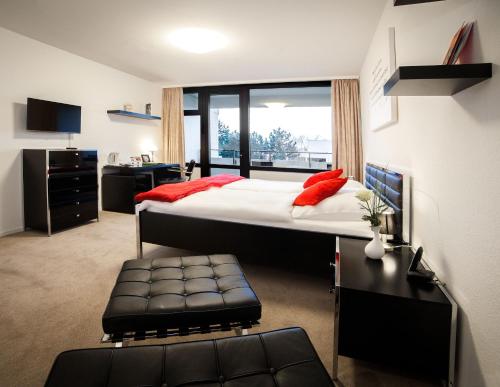 ハノーファーにあるアイレンリーダスティフト アパートメントのベッドルーム1室(大型ベッド1台、赤い枕付)