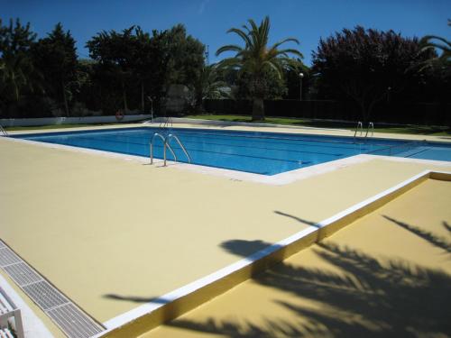 - une piscine dans un complexe avec des arbres en arrière-plan dans l'établissement Camping Sitges, à Sitges